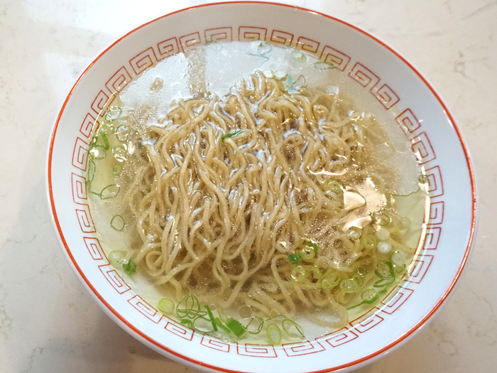 Μπολ shio ramen με διαυγή, ελαφρύ ζωμό, κυματιστά noodles και ψιλοκομμένο πράσινο κρεμμύδι.
