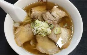 Μπολ με Kitakata ράμεν: διαυγής ζωμός shoyu, φέτες chashu, φρέσκο κρεμμυδάκι και χοντρά κυματιστά νουντλς
