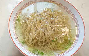 Μπολ shio ramen με διαυγή, ελαφρύ ζωμό, κυματιστά noodles και ψιλοκομμένο πράσινο κρεμμύδι.